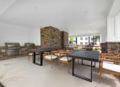 Thumbnail 16 of 35 - the pavilion dining area with tables and chairs and a brick fireplace at The Enclave at Deer Moss Creek, Niceville, FL