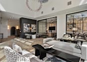Thumbnail 16 of 52 - A modern living room with a grey sofa and a black coffee table.