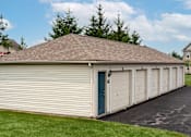 Thumbnail 16 of 21 - A long building with a blue door and a brown roof.