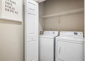Thumbnail 13 of 45 - A small laundry room with a washer and dryer.