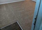 Thumbnail 1 of 20 - A room with a carpeted floor and a doorway leading to another room.