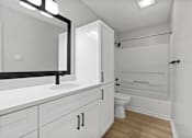 Thumbnail 40 of 67 - A white bathroom with a toilet, sink, and bathtub.