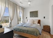 Thumbnail 18 of 51 - A bedroom with a large bed and a view of the outdoors through the window.