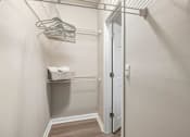 Thumbnail 6 of 45 - A white closet with a door and a shelf.