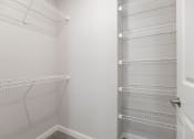 Thumbnail 6 of 29 - an empty closet in a bathroom with white shelves and a door