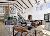 Thumbnail 1 of 51 - A living room with a brown leather couch and a white coffee table.