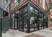 Thumbnail 45 of 46 - the corner of a city street with a building with glass doors