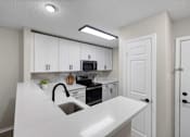 Thumbnail 8 of 67 - A kitchen with white cabinets and a white countertop.