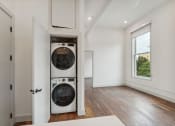 Thumbnail 3 of 46 - a front loading washer and dryer in a white room with wood flooring