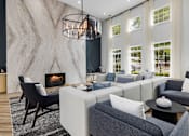 Thumbnail 17 of 45 - A modern living room with a fireplace and a large grey sofa.