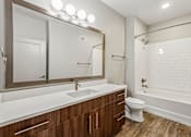 Thumbnail 44 of 64 - A modern bathroom with a white sink and a white toilet.