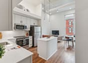 Thumbnail 13 of 46 - an open kitchen and living room with white cabinets and a white counter top