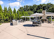 Thumbnail 25 of 50 - A patio with a table and chairs under a white umbrella.