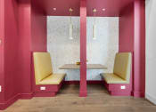 Thumbnail 23 of 35 - a pink waiting room with two yellow chairs and a table at The Enclave at Deer Moss Creek, Florida, 32578