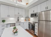 Thumbnail 14 of 46 - a large kitchen with stainless steel appliances and white cabinets
