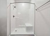 Thumbnail 34 of 51 - A white bathroom with a glass shower stall.