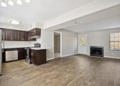 Thumbnail 8 of 33 - an empty living room with a kitchen and a fireplace
