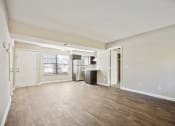 Thumbnail 16 of 33 - the living room and kitchen of an empty apartment with wood flooring