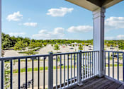 Thumbnail 47 of 51 - A view from a balcony overlooking a street with cars and trees.