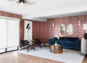 Thumbnail 27 of 33 - a living room with a blue couch and a brick wall
