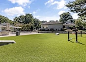 Thumbnail 35 of 50 - A green artificial turf field with a building in the background.