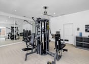 Thumbnail 22 of 45 - A gym with a variety of equipment including a treadmill, weights, and a bench press.