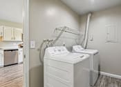 Thumbnail 34 of 54 - A white dryer and washer in a laundry room.