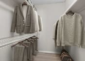 Thumbnail 26 of 67 - A row of clothes hanging on a rack in a room.