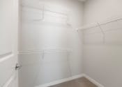 Thumbnail 13 of 29 - a spacious walk in closet in a 2020 manufactured home with white walls and hanging shelves