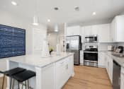 Thumbnail 8 of 29 - a large kitchen with white cabinets and stainless steel appliances