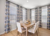 Thumbnail 9 of 29 - a dining room with white chairs and a wooden table