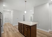 Thumbnail 13 of 31 - A kitchen with a white counter top and wooden floors.