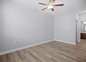Thumbnail 9 of 31 - A room with a ceiling fan and wooden flooring.