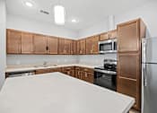 Thumbnail 6 of 31 - A kitchen with brown cabinets and a white countertop.