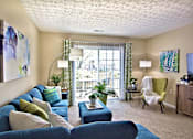 Thumbnail 3 of 21 - A living room with a blue couch and a green chair.