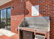 Thumbnail 21 of 40 - A metal grill is attached to a brick wall outside a building.