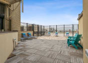Thumbnail 34 of 46 - a patio with chairs and a grill at the villas at falling waters in west omaha