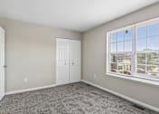 Thumbnail 38 of 54 - A room with a carpeted floor, a white door, and a window with blinds.