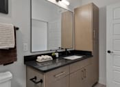 Thumbnail 37 of 52 - A bathroom with a sink, mirror, and cabinets.