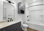 Thumbnail 4 of 44 - A white toilet sits next to a sink in a bathroom.