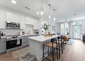 Thumbnail 1 of 25 - A modern kitchen with a large island and bar stools.