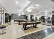 Thumbnail 28 of 46 - a spacious game room with two pool tables and a bar