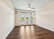 Thumbnail 25 of 51 - A room with a ceiling fan and wooden flooring.