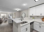 Thumbnail 11 of 67 - A modern kitchen with white cabinets and a large island.