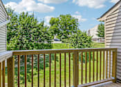 Thumbnail 41 of 54 - A wooden deck overlooks a grassy area with trees.
