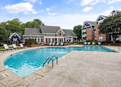 Thumbnail 30 of 45 - A large swimming pool in front of a building with a poolside lounge.