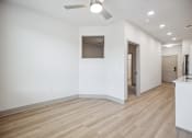 Thumbnail 10 of 31 - an empty living room with white walls and wood flooring at The Falstaff, Raleigh, NC
