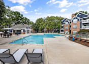 Thumbnail 31 of 45 - A pool surrounded by lounge chairs and trees.