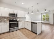 Thumbnail 14 of 31 - a large kitchen with white cabinets and stainless steel appliances at The Falstaff, North Carolina