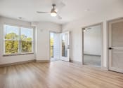 Thumbnail 18 of 31 - an empty living room with a sliding glass door and a ceiling fan at The Falstaff, Raleigh